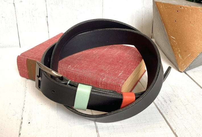 A dark brown leather belt on a red book