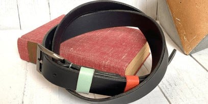 A dark brown leather belt on a red book
