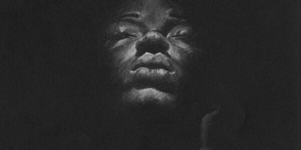 A drawing of a women's face on a black background
