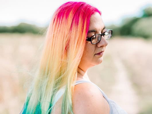 A photograph of a women with rainbow hair
