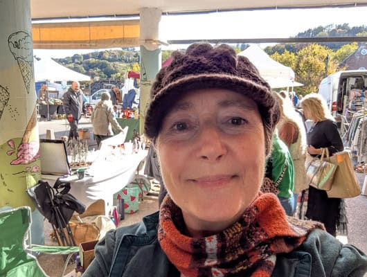 A picture of a lady with a hat on at a market