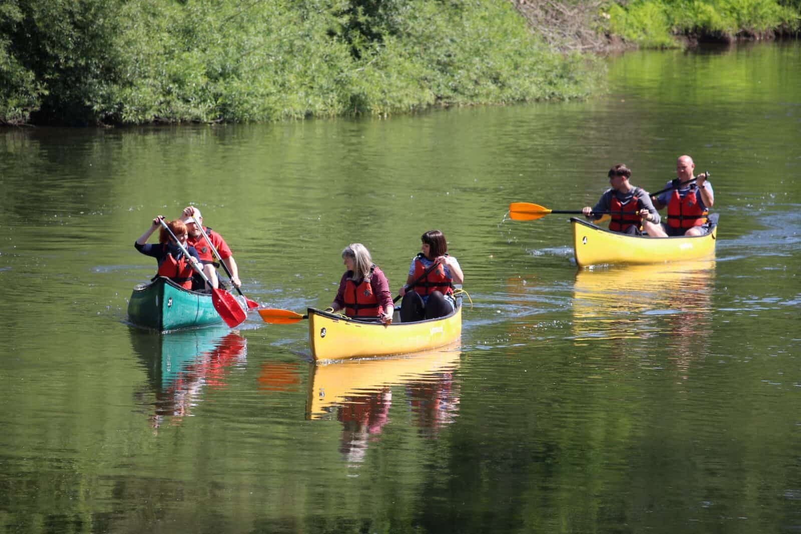 group of adults canoeing