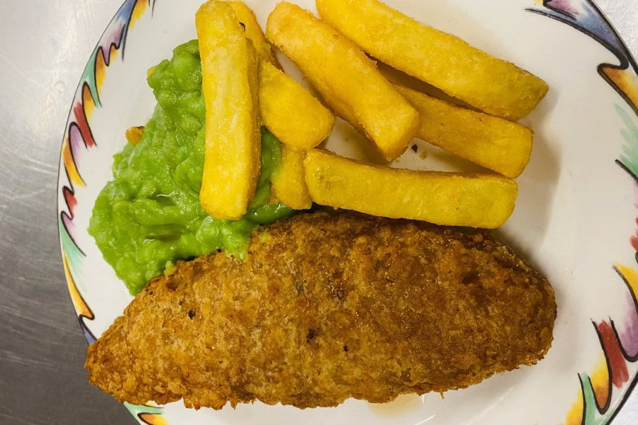 Fish, chips and mushy peas on a plate