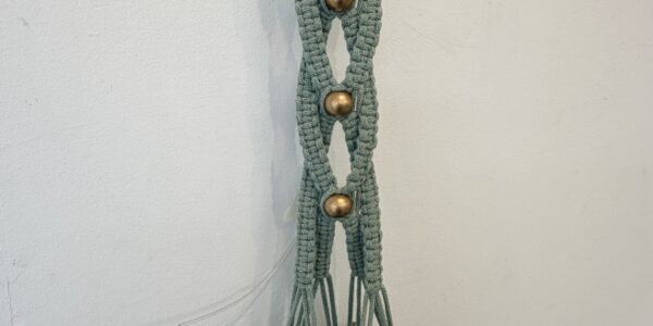 A macrame potholder with a plant inside it.