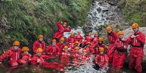A photo of young people in a river Ghyll scrambling - +Adventure Camp